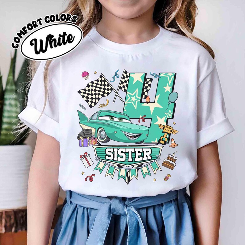 May include: White t-shirt with a teal car graphic, the number 4, and the word "SISTER". The design includes checkered flags, stars, and birthday-themed elements. The shirt has the words "COMFORT COLORS" and "White" in a circular design.
