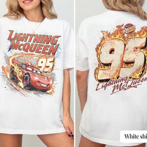Puede incluir: Camiseta blanca con Lightning McQueen de la pel&iacute;cula Cars. El frente muestra el personaje y texto, mientras que la parte posterior muestra un gran "95" con llamas y el nombre del personaje. Un dise&ntilde;o divertido y colorido.