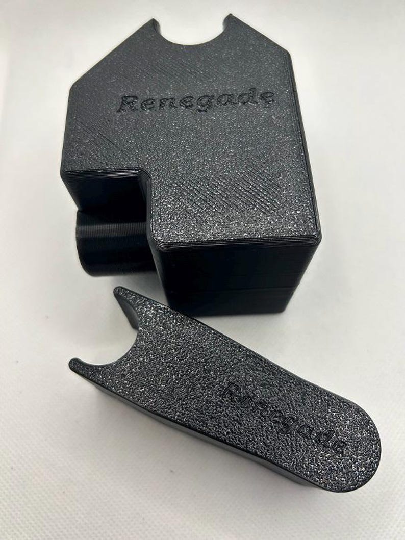 May include: Black textured plastic holder and tool. The holder has a rectangular shape with a curved top and the word "Renegade" embossed on the front. The tool is a flat, curved shape with the word "Renegade" embossed on it.