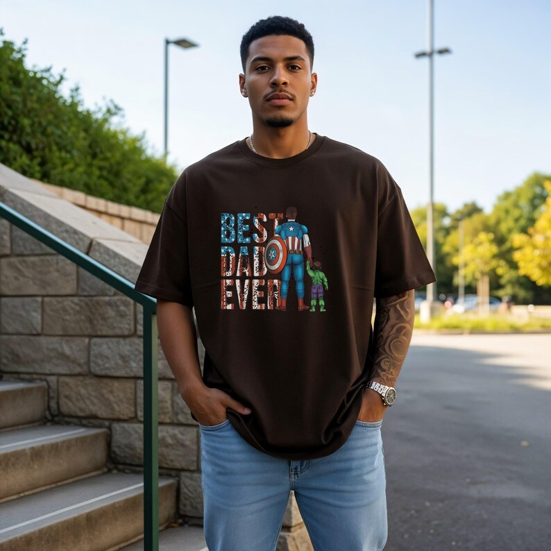 A man wearing a t-shirt with the text "BEST DAD EVER" standing in front of a stone wall and a staircase.