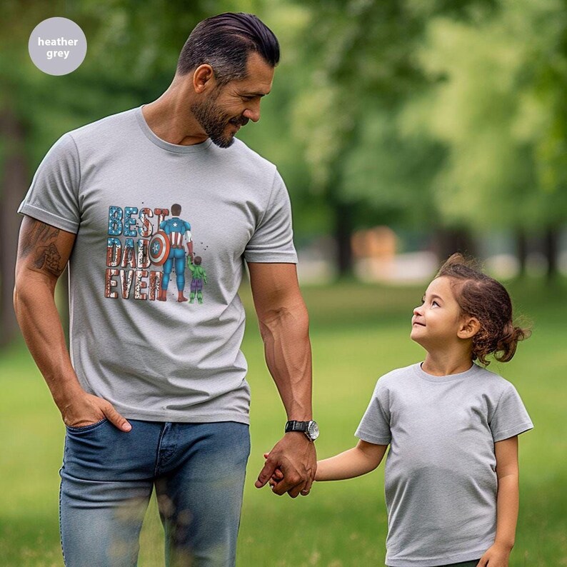 A man and a young girl are standing together in a park, holding hands and smiling.