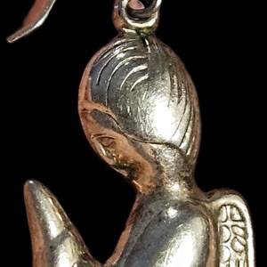 Puede incluir: Pendiente de &aacute;ngel plateado con dise&ntilde;o detallado. El &aacute;ngel se representa en posici&oacute;n de oraci&oacute;n, con delicadas alas y una expresi&oacute;n serena. El pendiente tiene un gancho curvado, ideal para joyer&iacute;a religiosa o espiritual.