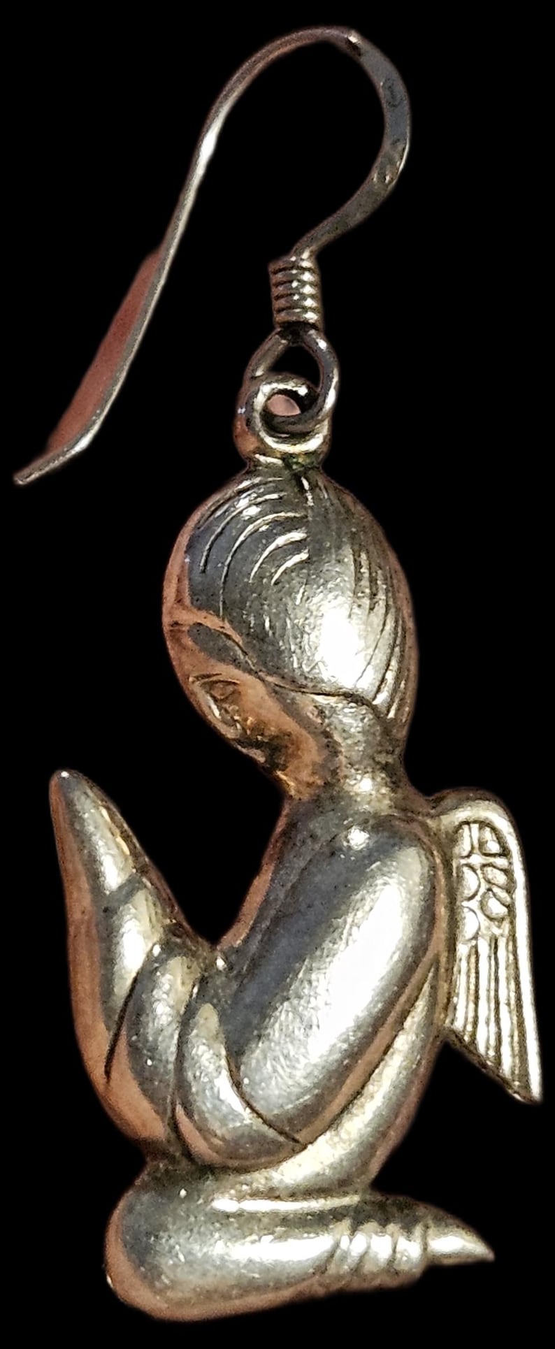 Puede incluir: Pendiente de &aacute;ngel plateado con dise&ntilde;o detallado. El &aacute;ngel se representa en posici&oacute;n de oraci&oacute;n, con delicadas alas y una expresi&oacute;n serena. El pendiente tiene un gancho curvado, ideal para joyer&iacute;a religiosa o espiritual.