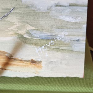 Pu&ograve; includere: Dipinto ad acquerello di un paesaggio costiero con toni tenui di verde, beige e blu. L'opera presenta una linea di costa con uno sperone roccioso e la firma dell'artista, "Hovels". Il dipinto &egrave; su carta.