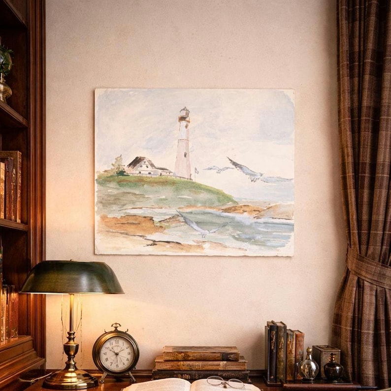 Pu&ograve; includere: Dipinto ad acquerello di una scena costiera con un faro su una collina verde e gabbiani in volo. L'opera d'arte &egrave; esposta sopra una scrivania con una lampada, un orologio, libri e un libro aperto con occhiali.
