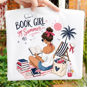 Op de afbeelding: Een wit t-shirt met een grafische illustratie van een persoon die een boek leest op een strandlaken. De tekst luidt BOOK GIRL Summer. Het ontwerp bevat een stapel boeken, een palmboom, een strandstoel, een tas en een drankje met een rietje.