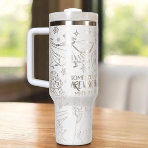 May include: White travel mug with a silver lid, handle, and accents. The mug features illustrations of characters and snowflakes, with the text "SOME PEOPLE ARE WORTH MELTING FOR."