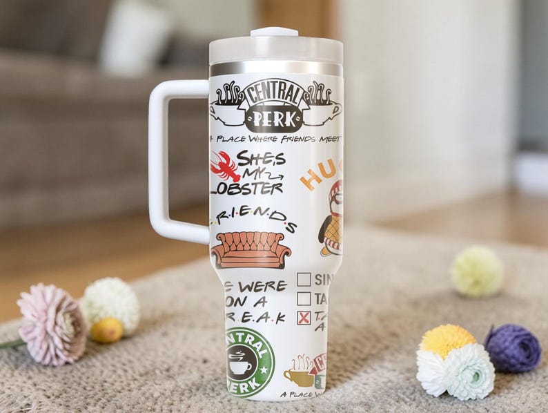 Puede incluir: Taza de viaje blanca con asa, con el logo "Central Perk" y varias citas e im&aacute;genes de la serie de televisi&oacute;n "Friends". La taza incluye una tapa y un asa blanca. La taza est&aacute; decorada con una langosta, un sof&aacute; y un ping&uuml;ino.