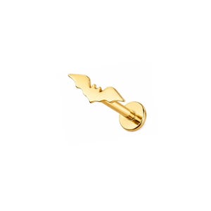 May include: A gold-toned flat back stud earring featuring a small, stylized bat-shaped charm. The piece consists of a thin post attached to a circular base, with the bat silhouette positioned at the end of the post, creating a cohesive metal design.