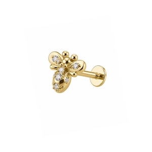 May include: A gold bee-shaped stud earring featuring a flat back post. The bee design is crafted from polished gold and is accented with small, clear, round-cut stones embedded along the wings and the body of the insect-shaped jewelry piece.