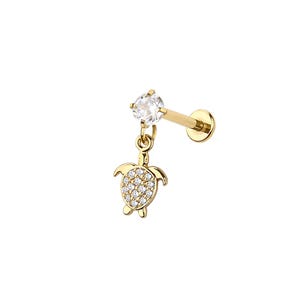 Puede incluir: Un piercing labial dorado con un dije de tortuga colgante. La tortuga está adornada con pequeñas piedras preciosas transparentes. El piercing presenta una piedra preciosa transparente en forma de corazón en la parte superior.