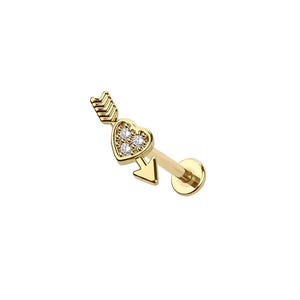 May include: A gold-colored lip piercing featuring a heart-shaped design pierced by an arrow. The heart is embellished with four small, clear gemstones. The piercing has a flat back and a straight post.