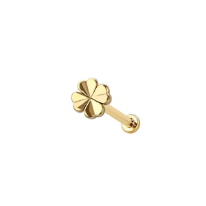 May include: A gold-colored, four-leaf clover stud earring. The earring features a flat, four-petal clover design at the top, connected to a straight post with a flat, round backing. The jewelry is set against a white background.