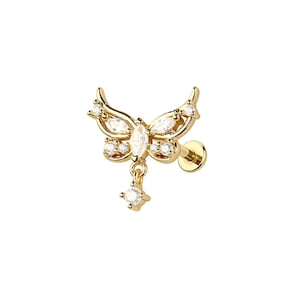 May include: A gold-colored butterfly-shaped earring with clear, sparkling gemstones. The earring features a butterfly design with a dangling gemstone. The earring is designed to be a stud earring.