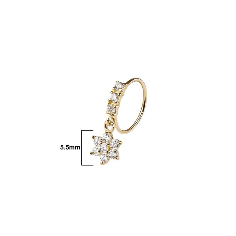 May include: A gold-colored nose ring with a dangling flower pendant. The ring features a row of four clear, square-cut stones and a flower pendant with multiple clear stones. The pendant measures 5.5mm.