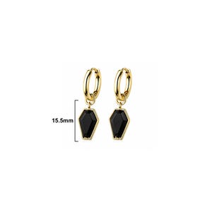 May include: A pair of gold-toned hoop earrings featuring dangling black coffin-shaped charms. The charms measure 15.5mm in length as indicated by the adjacent measurement graphic. The earrings have a polished metallic finish and a simple hinged closure.