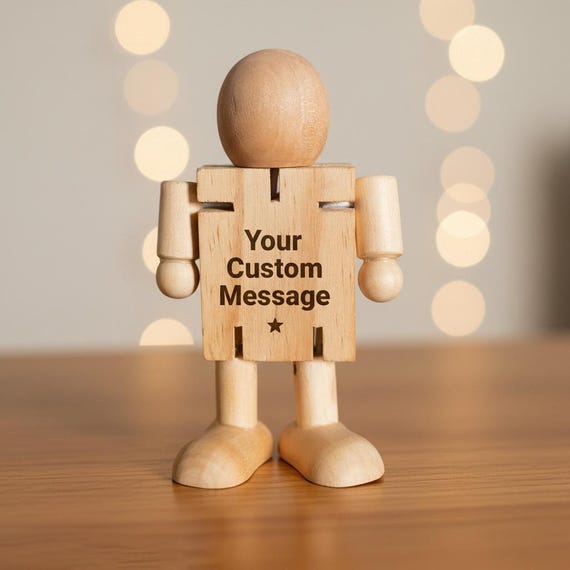 A poseable wooden figure laser-engraved with a custom name or message — the desk toy version of a personalized trophy.