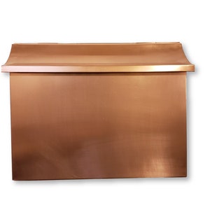 May include: A copper mailbox with a curved top and a smooth, slightly textured surface.