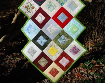 multicolored modern quilted table runner with toothed edges and striped back