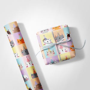 May include: A roll of gift wrap and a wrapped present, both decorated with a repeating pattern of cartoon cats wearing party hats. The cats are in various colours, set against pastel squares. The gift is tied with a light blue ribbon.