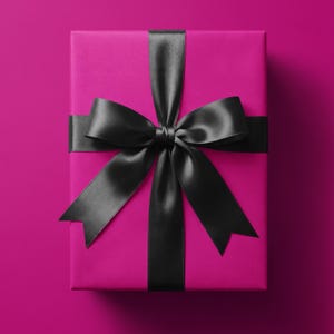 Peut inclure: Une boîte cadeau rectangulaire enveloppée dans du papier magenta uni. La boîte est nouée avec un large ruban de satin noir lisse formant un grand nœud centré, avec deux longs pans pointus tombant sur le devant de l'emballage.