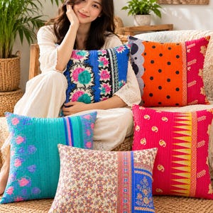 May include: Five square throw pillows featuring vibrant, multi-colored fabric patterns including floral, polka dot, and geometric designs. The pillows are quilted with visible stitching and showcase a variety of bright colors like blue, pink, orange, and yellow.