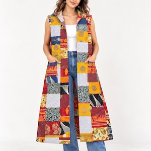 May include: A sleeveless, knee-length hooded vest featuring a patchwork design with various floral and geometric patterns in shades of mustard yellow, deep red, navy blue, and white, complete with two front patch pockets.