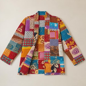 May include: A long-sleeved jacket featuring a vibrant patchwork design composed of various rectangular fabric segments. The garment displays a multitude of colours including red, yellow, blue, purple, and orange, with diverse floral and geometric patterns.