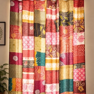May include: A floor-length curtain featuring a vibrant patchwork design of various rectangular fabric panels. The curtain displays a mix of colours including red, yellow, pink, and teal, with intricate floral and geometric patterns throughout.