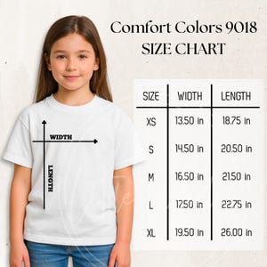 Puede incluir: Una persona joven con una camiseta blanca, con una tabla de tallas para Comfort Colors 9018. La tabla muestra tallas XS a XL, con medidas de ancho y largo en pulgadas. La talla XS mide 34,29 cm de ancho y 47,63 cm de largo.