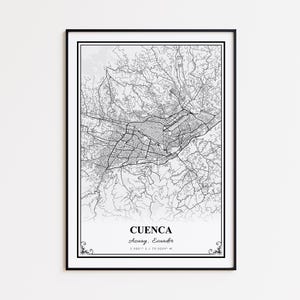 May include: A framed black and white map print of Cuenca, Ecuador. The map details the city's streets and surrounding areas. The city name and coordinates are printed at the bottom. The frame is black with a white border.
