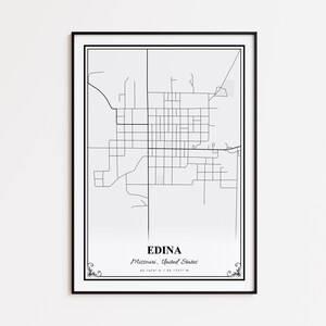 May include: A framed black and white map print of Edina, Missouri, United States. The map features a detailed street layout with the city's name and coordinates at the bottom. The print is encased in a black frame.