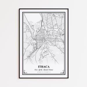 May include: Black framed print of a detailed map of Ithaca, New York, United States. The map is in black and white, showing streets, buildings, and surrounding areas. The city name and coordinates are printed at the bottom.