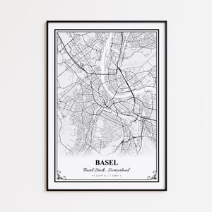May include: Black framed print of a detailed map of Basel, Switzerland. The map is in black and white, showcasing the city's streets and waterways. The city name and coordinates are printed at the bottom. Decorative flourishes are at the corners.