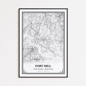 May include: Black framed map print of Fort Mill, South Carolina, United States. The map is a detailed black and white depiction of the city's roads and waterways. The city name and coordinates are printed at the bottom.
