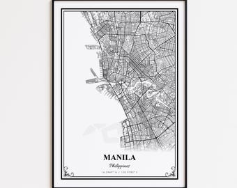 May include: A black and white framed map print of Manila, Philippines. The map details the city's layout with streets and waterways. The city name and coordinates are printed at the bottom. The frame is black.