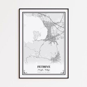 May include: A framed black and white map print of Fethiye, Muğla, Türkiye. The map shows the city's layout with roads and geographical features. The city name and coordinates are printed at the bottom. The print is in a black frame.