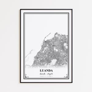 May include: Black framed print of a map of Luanda, Angola. The map is in black and white, showing the city's layout and surrounding areas. The city name and coordinates are printed at the bottom. Decorative flourishes are in the corners.