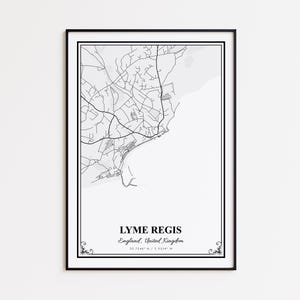 May include: A framed black and white map print of Lyme Regis, England. The map shows the town's streets and coastline. The text "LYME REGIS England, United Kingdom" is centered at the bottom, with coordinates below. Decorative flourishes are in the corners.