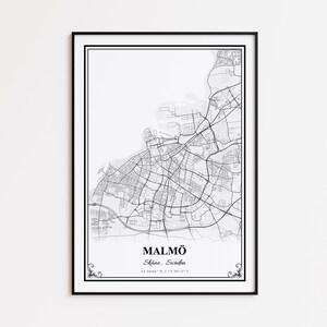 May include: Black framed print of a detailed map of Malmö, Sweden. The map is in black and white, showing streets and city layout. The city name and coordinates are printed at the bottom.