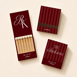 May include: Three matchbooks in deep burgundy with dark red vertical stripes. One open matchbook displays white-tipped wooden matches and the date 06.30.27. Another features the initials BK, while the third displays The Jacksons and 06.30.27.