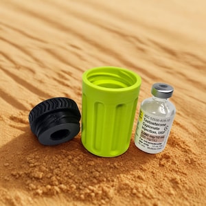 May include: A black cap, a lime green container, and a vial of Testosterone Cypionate Injection, USP 200 mg/mL are arranged on a sandy surface. The vial has a silver cap and a white label with black text.