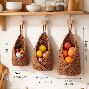May include: Three brown crocheted hanging baskets in small, medium, and large sizes. The small basket measures 15 x 28 cm, medium 18 x 35 cm, and large 20 x 40 cm. They are filled with fresh produce including peppers, garlic, lemons, onions, apples, and oranges.