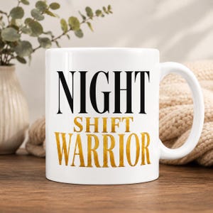 May include: A white ceramic mug featuring the text NIGHT in bold black capital letters, followed by SHIFT WARRIOR in metallic gold capital letters. The mug has a standard handle on the right side and a smooth, glossy finish on the exterior surface.
