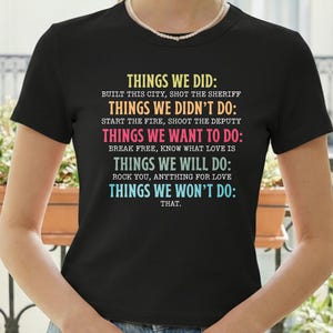 Könnte beinhalten: Schwarzes T-Shirt mit farbigem Text. Der Text lautet: "THINGS WE DID: BUILT THIS CITY, SHOT THE SHERIFF. THINGS WE DIDN'T DO: START THE FIRE, SHOOT THE DEPUTY. THINGS WE WANT TO DO: BREAK FREE, KNOW WHAT LOVE IS. THINGS WE WILL DO: ROCK YOU, ANYTHING FOR LOVE. THINGS WE WON'T DO: THAT."