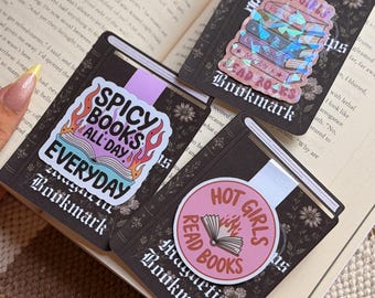 May include: Three rectangular magnetic bookmarks with black backgrounds and floral patterns. One features a stack of books with the text "HOT GIRLS READ BOOKS". Another displays "SPICY BOOKS ALL DAY EVERYDAY" with flames. The third shows "HOT GIRLS READ BOOKS" in a circle.