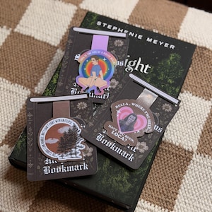 May include: Three magnetic bookmarks featuring Twilight-themed designs. One shows a character with the text 'THIS IS THE SKIN OF A KILLER BELLA', another a forest scene with 'THE CLOUDS I CAN HANDLE BUT I CAN'T FIGHT WITH AN ECLIPSE', and one with 'BELLA WHERE THE HELL HAVE YOU BEEN LOCA?'