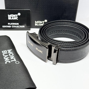 Puede incluir: Un cinturón de cuero negro con superficie texturizada y hebilla metálica con el logotipo de Montblanc. El conjunto incluye una bolsa de almacenamiento negra y una tarjeta con la inscripción Montblanc Platinum Leather Collection y una caja negra.