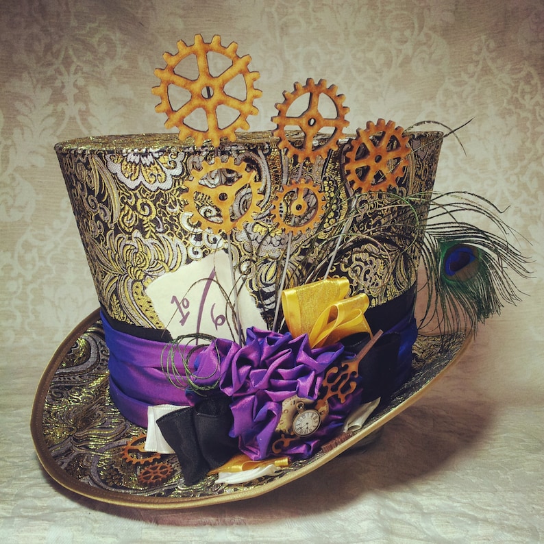 May include: A black and gold top hat with a purple ribbon, a purple flower, and gold gears. The hat is decorated with a peacock feather and a piece of paper with the text "1/6".