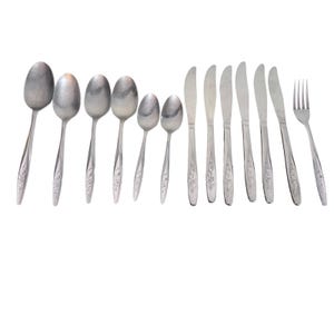 May include: A set of stainless steel cutlery, comprising spoons, knives, and a fork. The spoons are of varying sizes, and all handles display a floral pattern. The cutlery is arranged against a white backdrop.